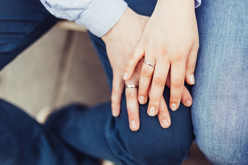 Couple hands with marriage proposal gold rings holding hands together