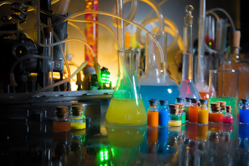 Pharmacy and chemistry theme. Test glass flask with solution in research laboratory. Science and medical background. Laboratory test tubes on dark toned background