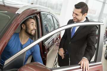 Fototapeta na wymiar Young African man buying a car from a professional salesman