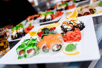 a set of sushi with wasabi ginger and a glass of whiskey