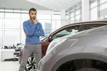 Fototapeta na wymiar Handsome young African man buying a new automobile at the dealership