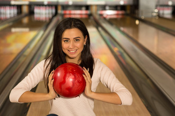 Fototapeta na wymiar Beautiful young woman posing with a ball at the bowling club