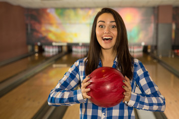 Gorgeous young female bowling player posing with the bowling ball