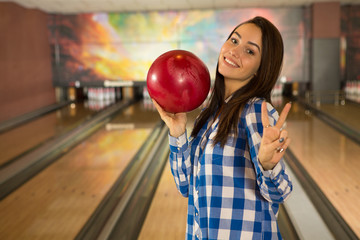 Gorgeous young female bowling player posing with the bowling ball