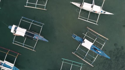 Aerial drone view of boats anchored in the bay with clear and turquoise water. Boat and yacht in the tropical lagoon. Tropical landscape. El Nido, Palawan island, Philippines.