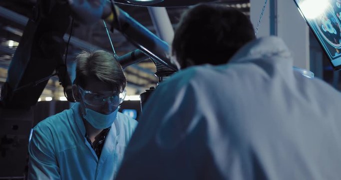 Scientists surgeons discuss the operation. Men are dressed in white robes and glasses, working in the scientific laboratory of the spacecraft.