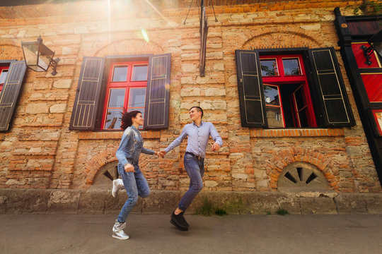 couple running fast neat brick building with red windows