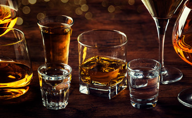 Selection of hard strong alcoholic drinks big glasses and shot glass in assortment: vodka, cognac,...