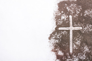 Cross and ash on white background - symbol of Ash Wednesday. Copy space - 252333881