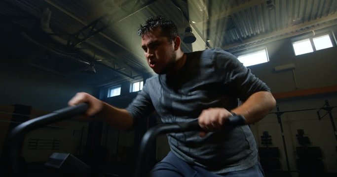 Overweight young man exercising with a machine