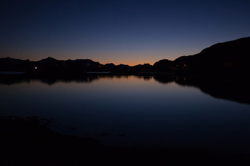 Landscape sillhouette with light on the horizon after sunset. Cloudless, dark blue and symmetrical...