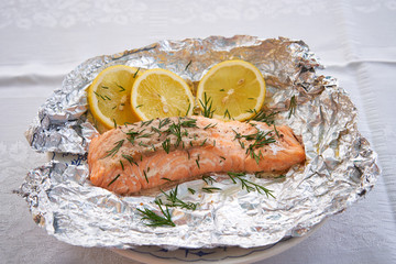 Close up picture salmon fillet baked in aluminium baking foil, low fat, fresh, healty dish served...