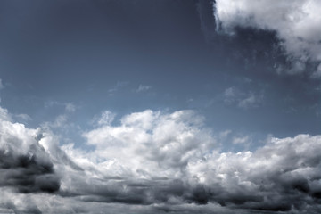 white and dark clouds at a blue sky