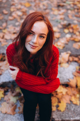 Fototapeta na wymiar Close up outdoor portrait of caucasian ginger dreaming and smiling sensual tender young girl in autumn park. Beauty, nature, seasons, emotions concept