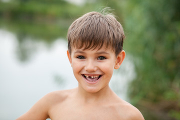 Fototapeta na wymiar portrait of a toothless child 5-6 years old in nature in summer