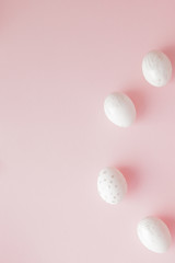 White Easter eggs on pink background with copy space. Top view shot of arrangement decoration Happy Easter holiday background concept. Design pastel tone in minimal flat lay