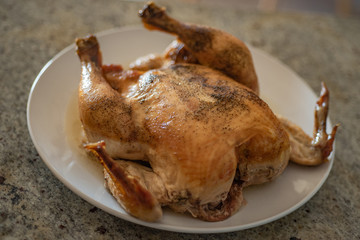 Whole chicken grill on white dish.