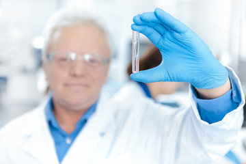 Professional laboratory technician holding a test tube at the laboratory