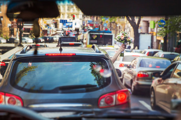 bouquet of flowers from the car window in the hands of the girl