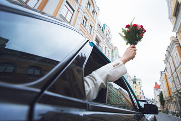 bouquet of flowers from the car window in the hands of the girl