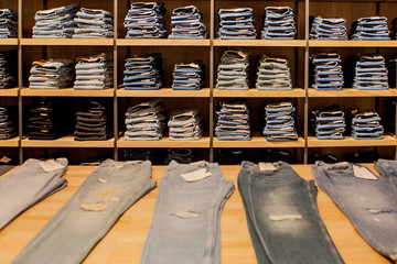 Fototapeta na wymiar Jeans pants on the store shelf. Blue jeans denim Collection jeans stacked