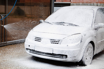 Car wash with foam in car wash station. Carwash. Washing machine at the station. Car washing...