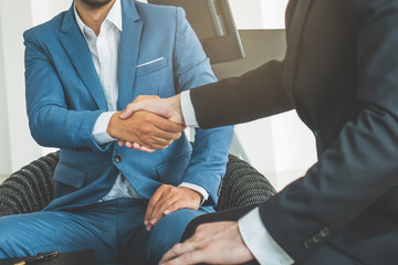 Two businessmen doing handshake after deal negotiation complete.