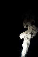 Vape steam column with spray boiling liquid. Stock photo isolated on black background.