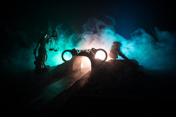 Legal law concept. Silhouette of handcuffs with The Statue of Justice on backside with the flashing...