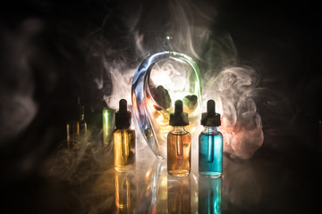 Vape concept. Smoke clouds and vape liquid bottles on dark background. Light effects. Useful as background or electronic cigarette advertisement.