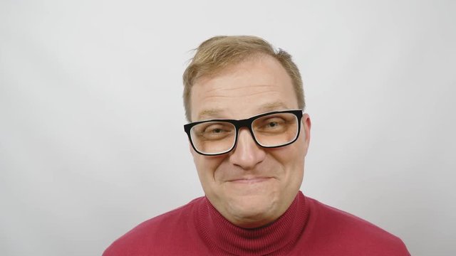 Young handsome man in red sweater posing for the camera. Handsome emotional man. A young man expresses different emotions. Emotions face and handsome hands.close-up