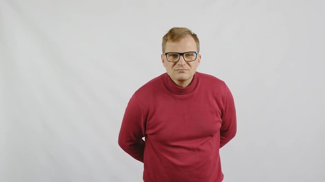 Young handsome man in red sweater posing for the camera. Handsome emotional man. A young man expresses different emotions. Emotions face and handsome hands