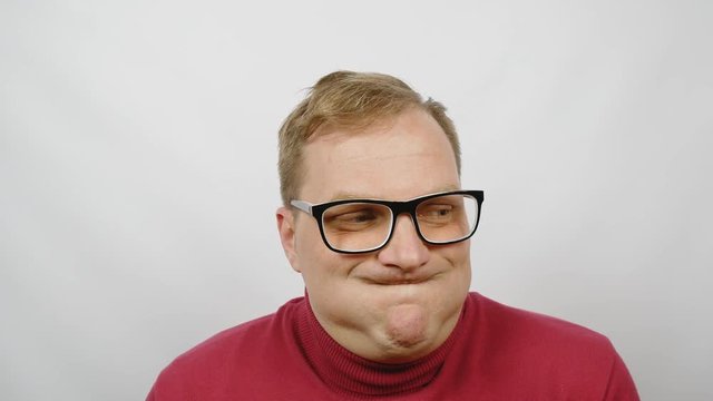 Young handsome man in red sweater posing for the camera. Handsome emotional man. A young man expresses different emotions. Emotions face and handsome hands.close-up