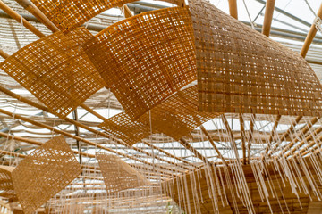 Basketwork made of bamboo used as decorative items on the ceiling in a botanical garden.