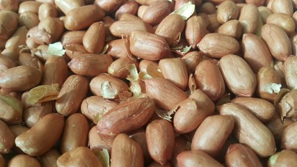 Closeup view of mixed, dried, roasted  peeled and unpeeled peanuts.