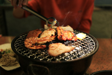 Grilling barbecue on mesh grill of charcoal fire. Korean or japanese traditional food grilling style barbecue.