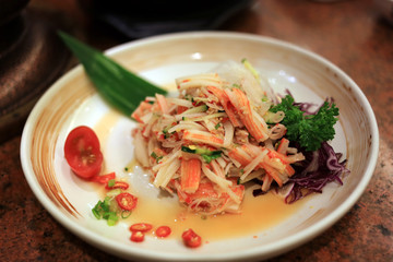 Imitation crab stick spicy salad in white dish. 