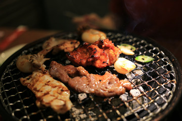 Barbecue meat on grilling mesh of charcoal fire. Korean or japanese traditional food grilling style barbecue.