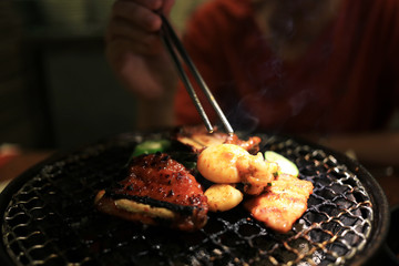 Barbecue meat on grilling mesh of charcoal fire. Korean or japanese traditional food grilling style barbecue.