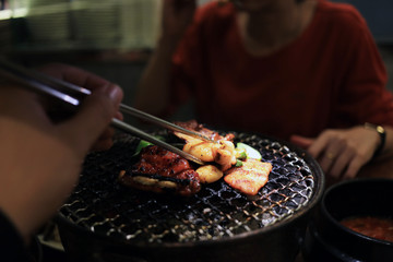 Barbecue meat on grilling mesh of charcoal fire. Korean or japanese traditional food grilling style barbecue.