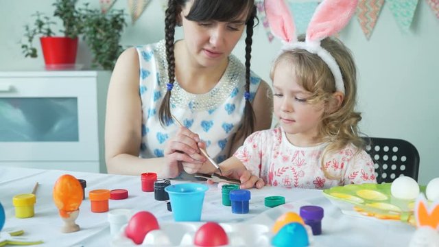 Little Girl Painting Wooden Easter Bunny with Mom
