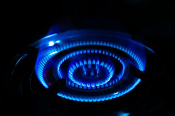 Blue of fire burning in kitchen on the dark background.