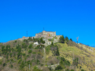 Medieval fort Sperone on the top of the mountain against a bright blue sky, Genoa, Italy