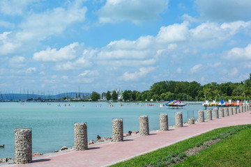 Beautiful beach with sailing boats and paddle boats at the Lake Balaton