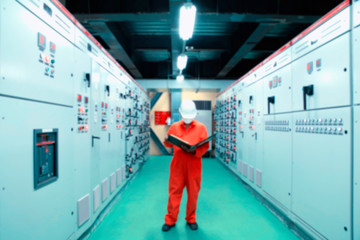 Engineer checking and monitoring the electrical system in Electrical switch gear at Low Voltage motor control center cabinet room,Electrical button switch at night.