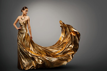 Woman Gold Dress, Fashion Model in Long Waving Fluttering Gown, Young Girl Beauty Studio Portrait