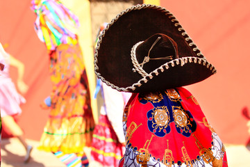 a small mexican child dressed with traditional carnival costume and mexican sombrero