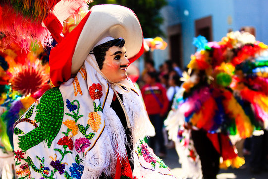a huehue mexican carnival dancer dancing with a colorful folk costume