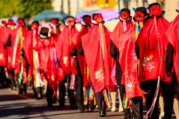 Obraz premium mexican huehue carnival dancers with red caps align in line before performing