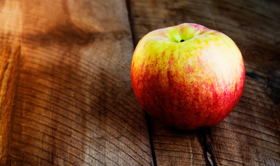 Red apple isolated on wooden table, closeup.